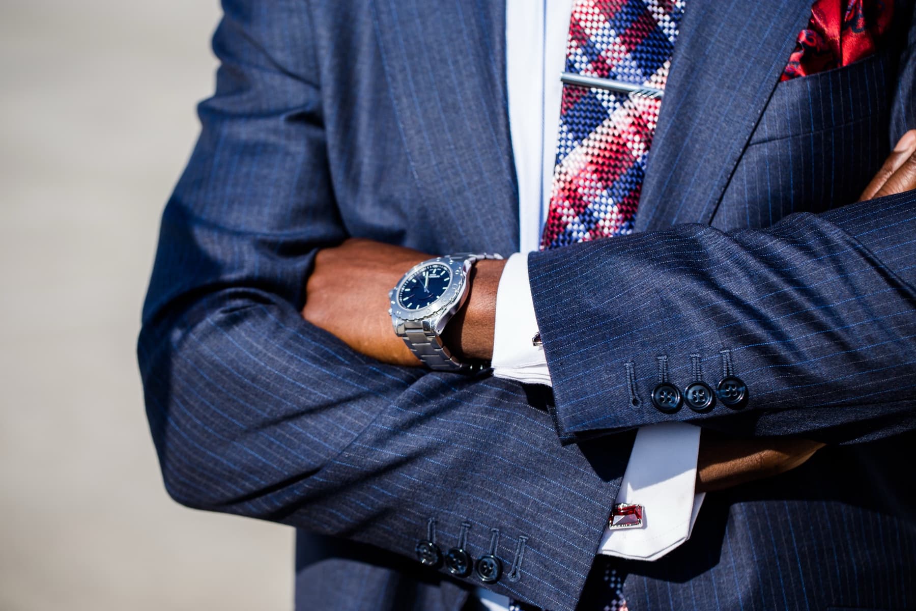 Detail shot of a custom suit cuff, tie, and watch