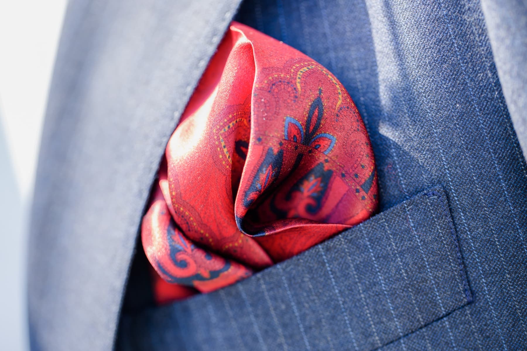 Macro detail of a folded silk pocket square in a custom suit jacket
