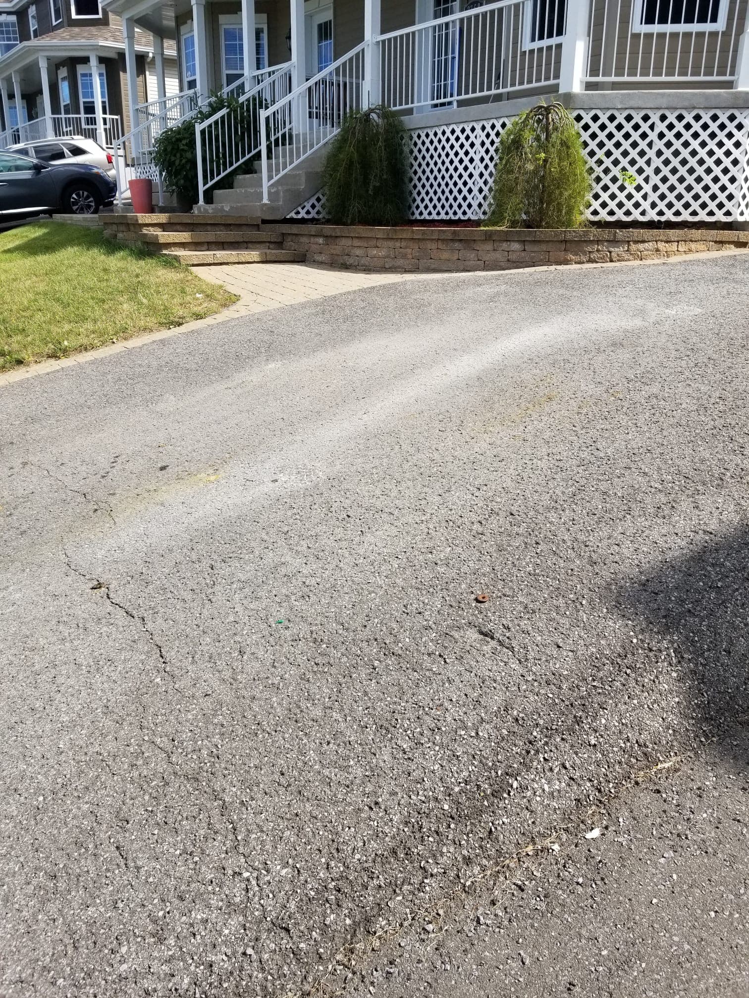 Close-up of the existing cracked driveway surface before paving